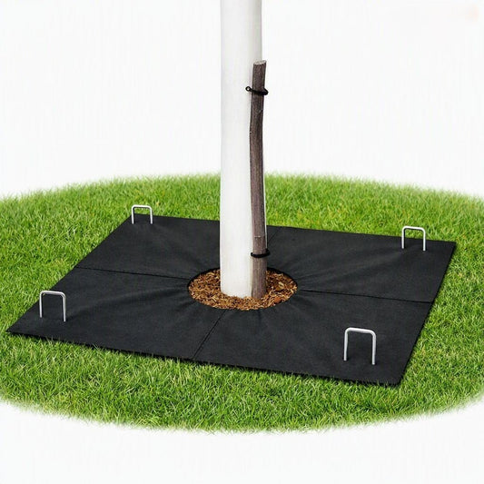 Tree mat installed around young tree with white protector and four ground staples on summer grass.”


